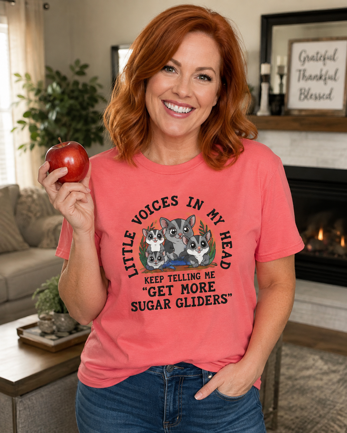 Woman wearing a funny sugar glider T-shirt featuring three sugar gliders and the phrase “Little Voices in My Head Keep Telling Me Get More Sugar Gliders.”